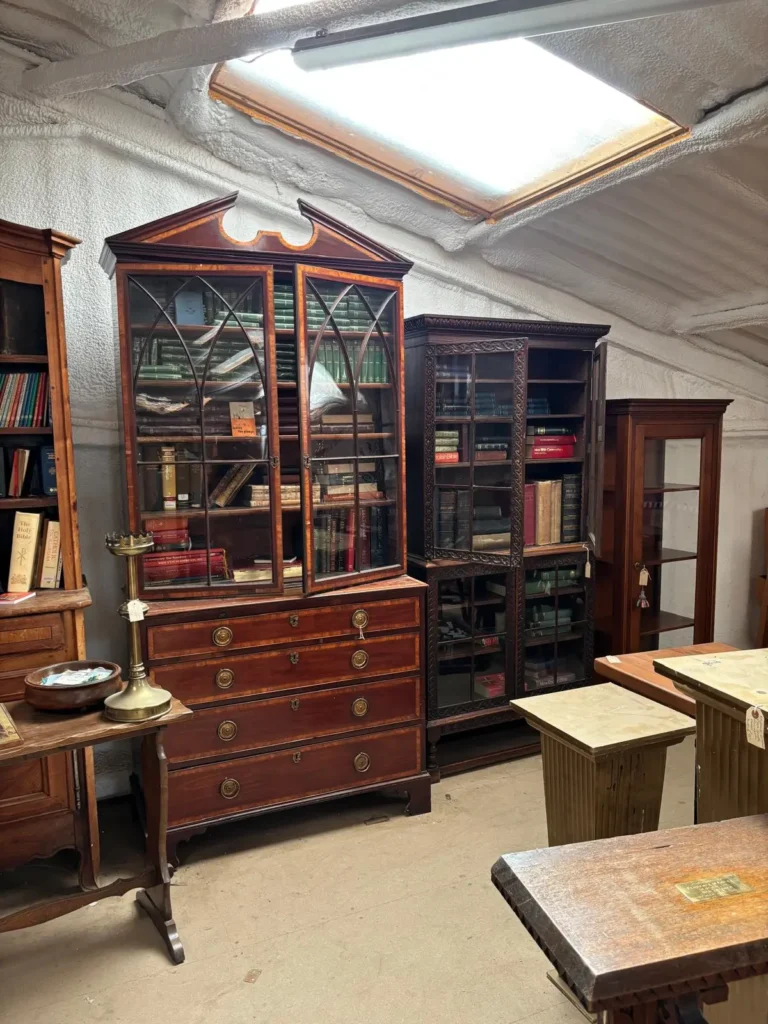 Georgian-style mahogany bookcases with glazed doors beneath a warehouse skylight