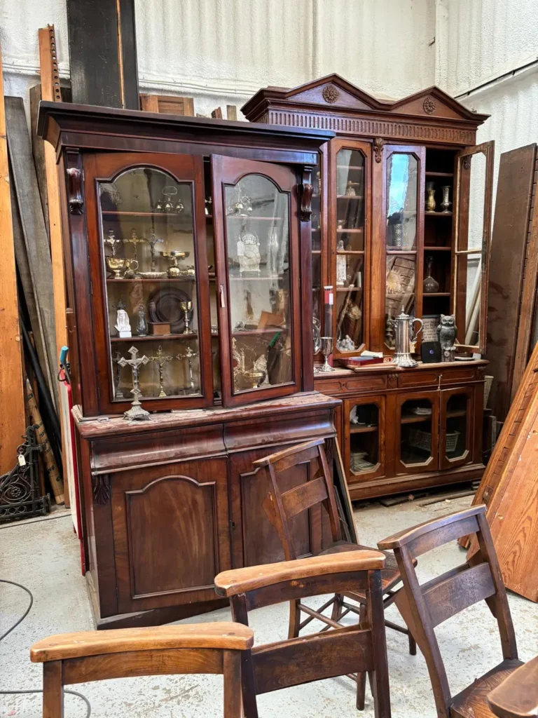Victorian-style mahogany glazed display cabinets holding church silver and crosses