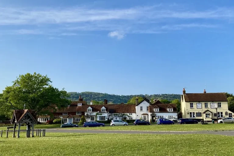 Brockham's village green, lined with cottages and a village pub, with Box Hill rising behind