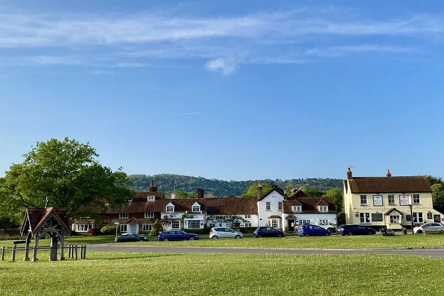 Brockham's village green, lined with cottages and a village pub, with Box Hill rising behind